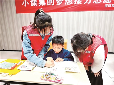 志愿者与孩子一起阅读书籍