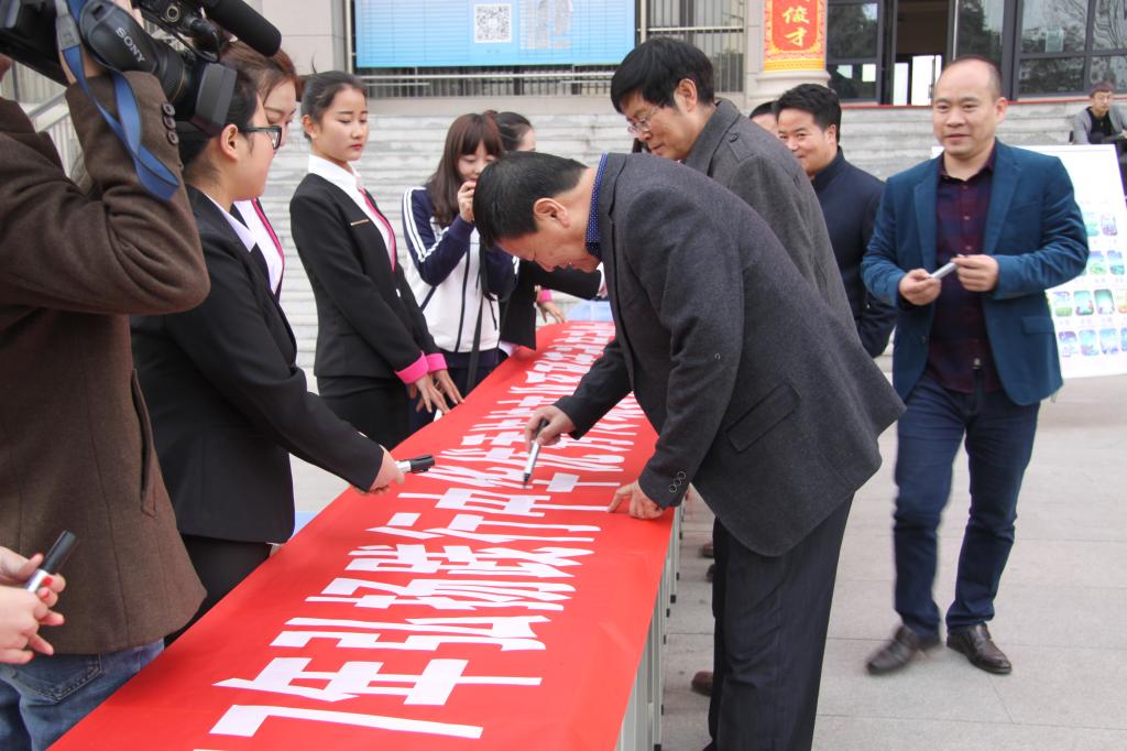 师生在横幅上签字留念